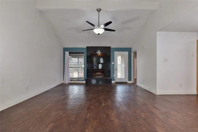 a view of a livingroom with wooden floor a ceiling fan and window