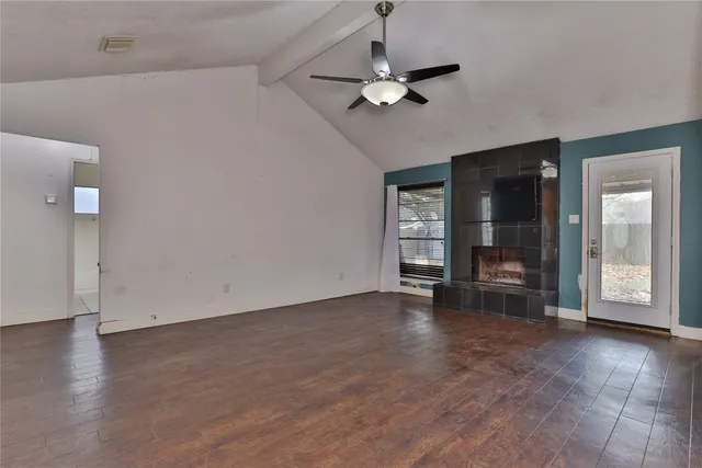 an empty room with wooden floor and mirror