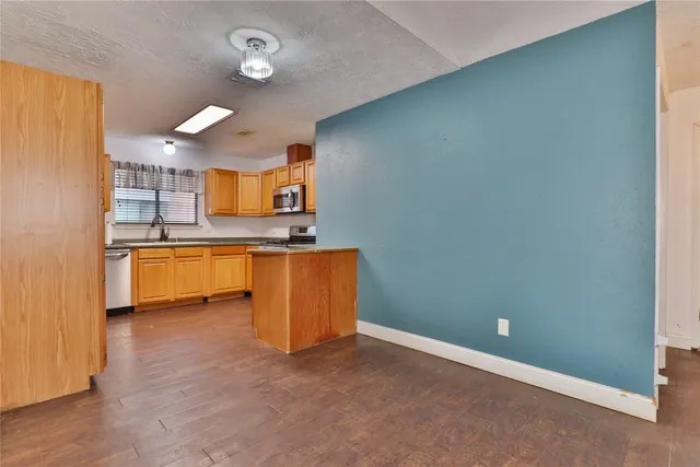 a kitchen with granite countertop a sink and a stove top oven