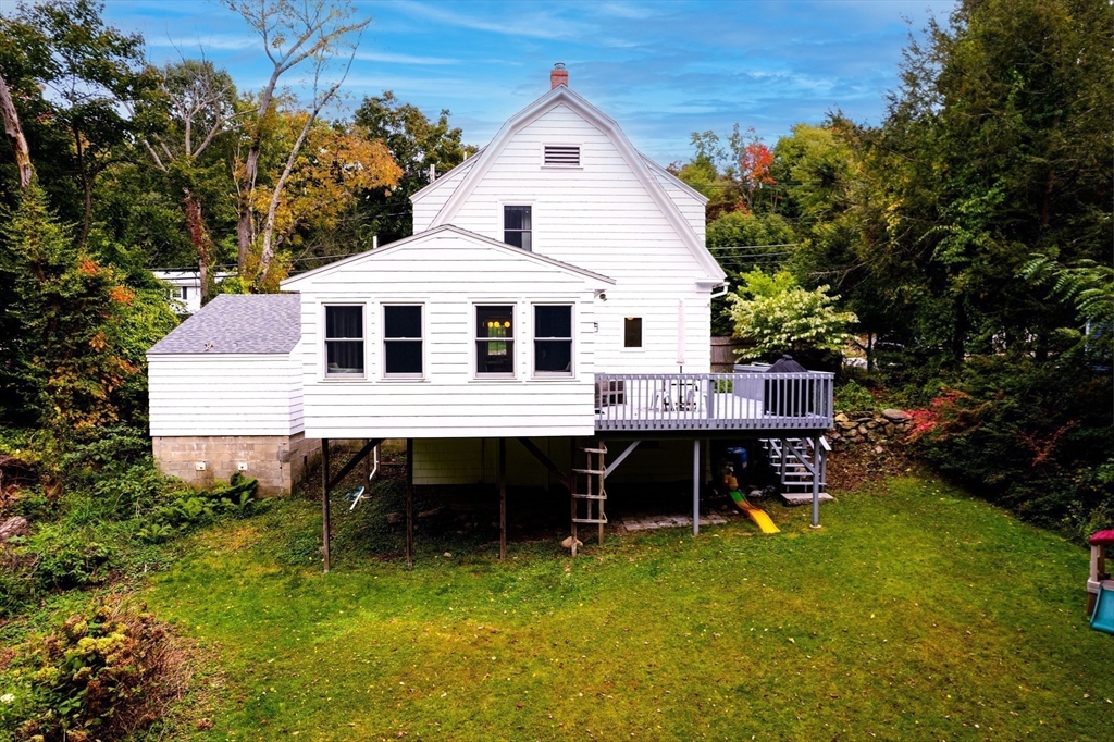 90 Main Street Acton, MA 01720 - Photo 31 of 38 a view of a house with a wooden deck and a yard