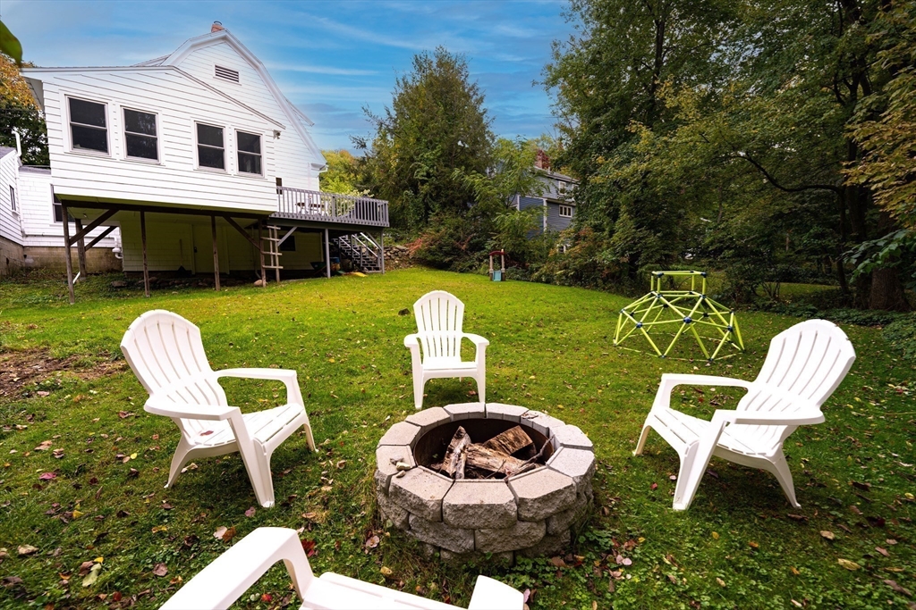 90 Main Street Acton, MA 01720 - Photo 33 of 38 a front view of a house with garden and chairs