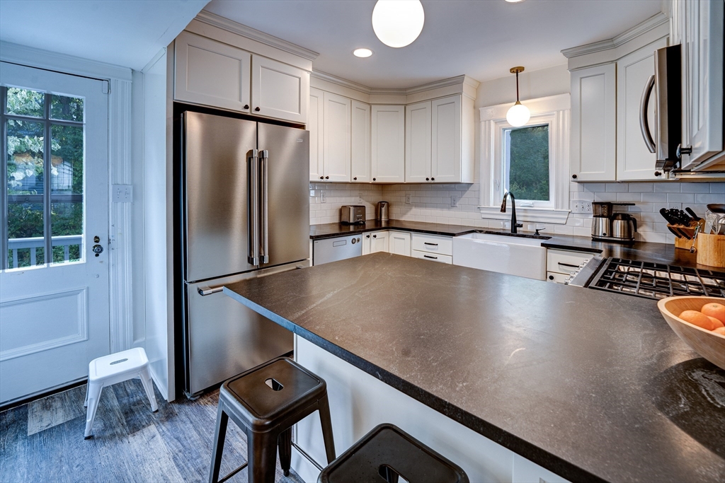 90 Main Street Acton, MA 01720 - Photo 5 of 38 a kitchen with a table chairs refrigerator and cabinets
