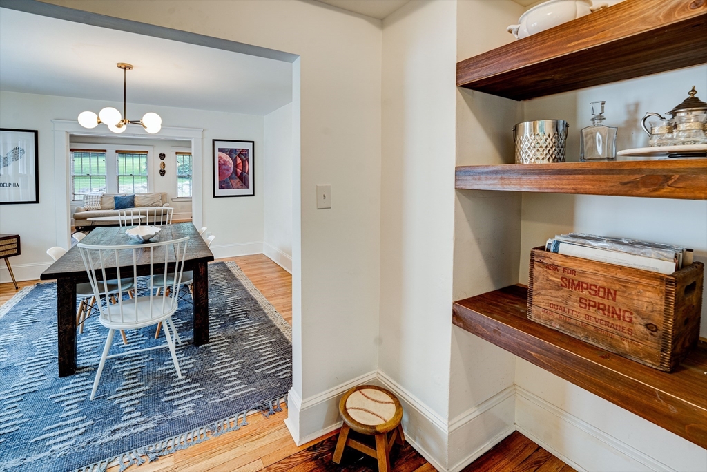 90 Main Street Acton, MA 01720 - Photo 10 of 38 a dining room with wooden floor a chandelier a wooden table and chairs