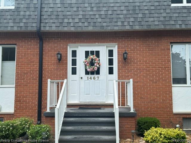 1467 Krafft Road, Unit 8 Port Huron, MI 48060 - Photo 3 of 28 Brick exterior featuring a white entry door with sidelights, dark gray shingle roof, and white railings flanking the entry steps