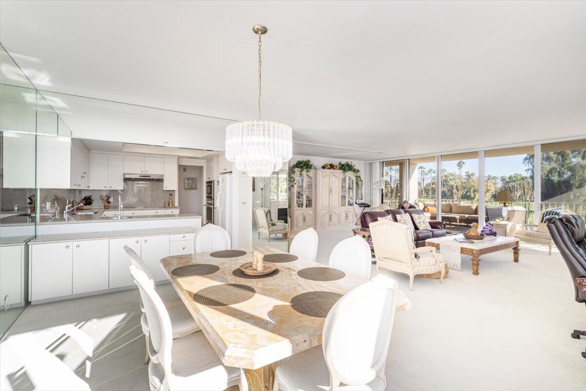 900 Island Drive, Unit 313 Rancho Mirage, CA 92270 - Photo 14 of 62 a view of a dining room with furniture a chandelier and large windows