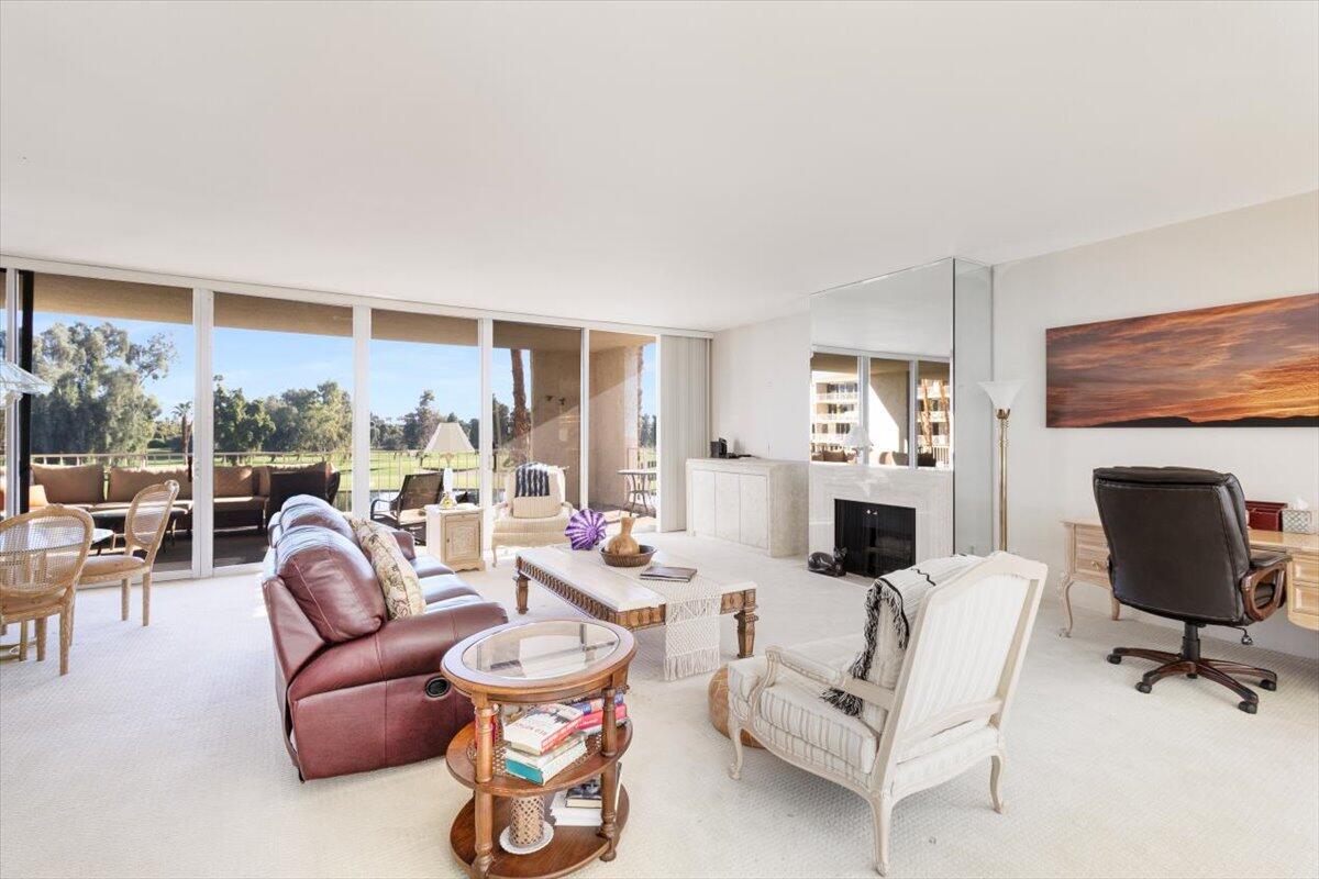 900 Island Drive, Unit 313 Rancho Mirage, CA 92270 - Photo 16 of 62 a living room with furniture a fireplace and a floor to ceiling window