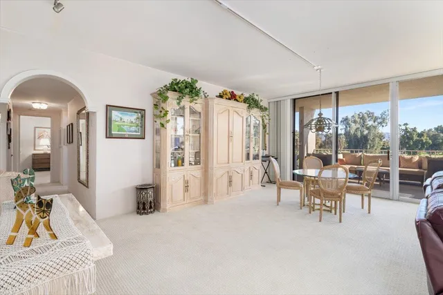a dining room with furniture a chandelier and wooden floor