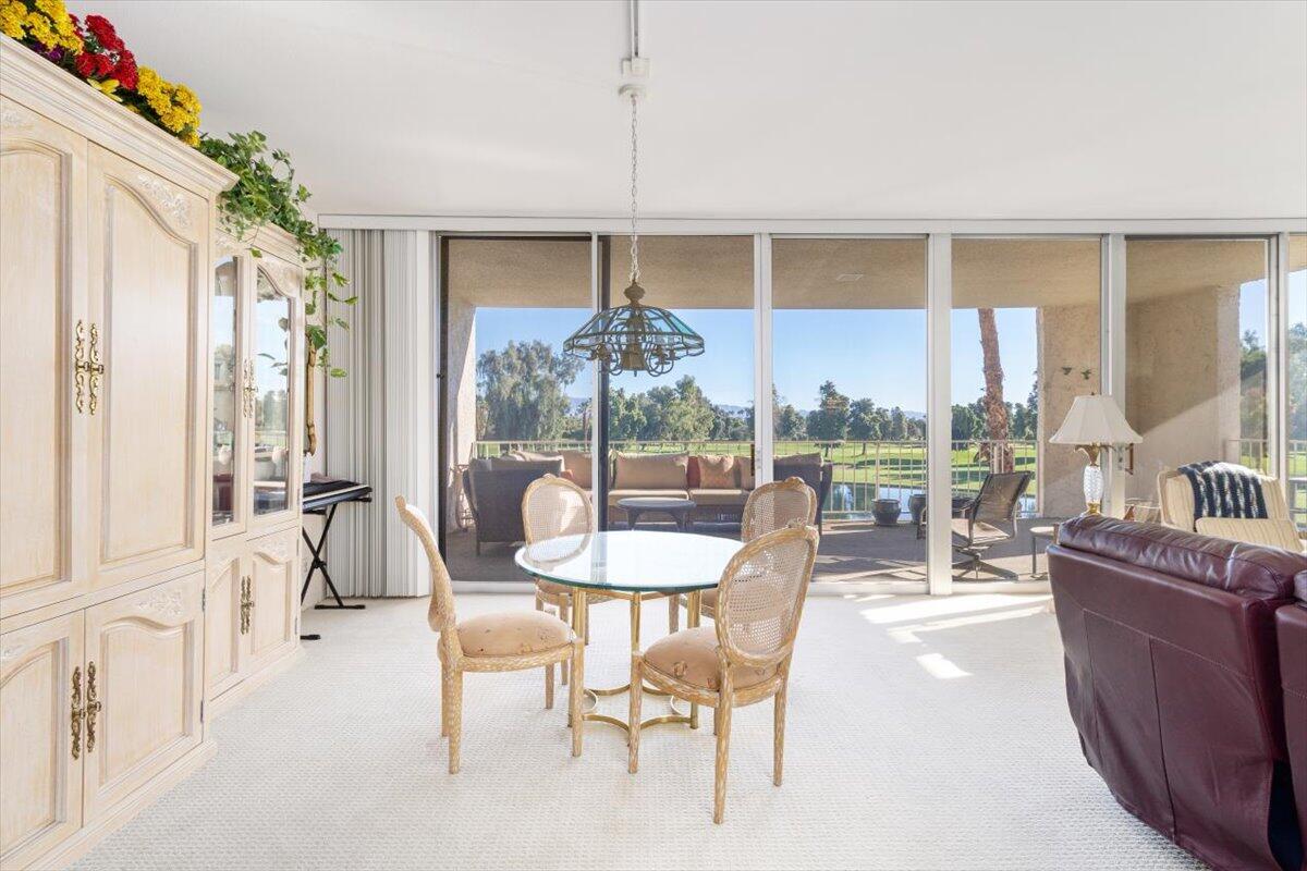 900 Island Drive, Unit 313 Rancho Mirage, CA 92270 - Photo 20 of 62 a dining room with furniture a chandelier and a rug