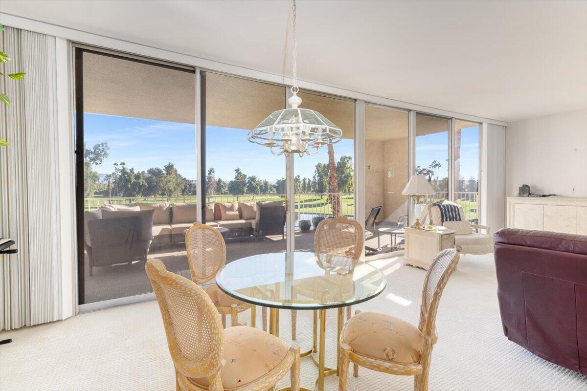 900 Island Drive, Unit 313 Rancho Mirage, CA 92270 - Photo 21 of 62 a dining room with furniture a chandelier and wooden floor