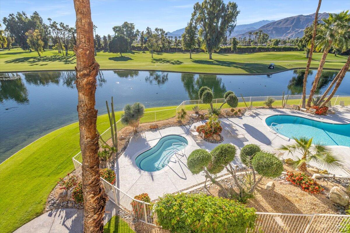 900 Island Drive, Unit 313 Rancho Mirage, CA 92270 - Photo 44 of 62 a view of a swimming pool with a lawn chairs under an umbrella
