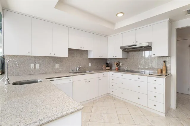a kitchen with granite countertop white cabinets white stainless steel appliances and sink