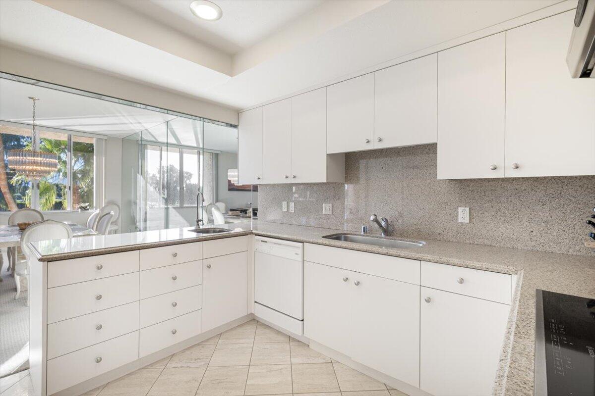 900 Island Drive, Unit 313 Rancho Mirage, CA 92270 - Photo 8 of 62 a kitchen with granite countertop white cabinets white appliances and a sink