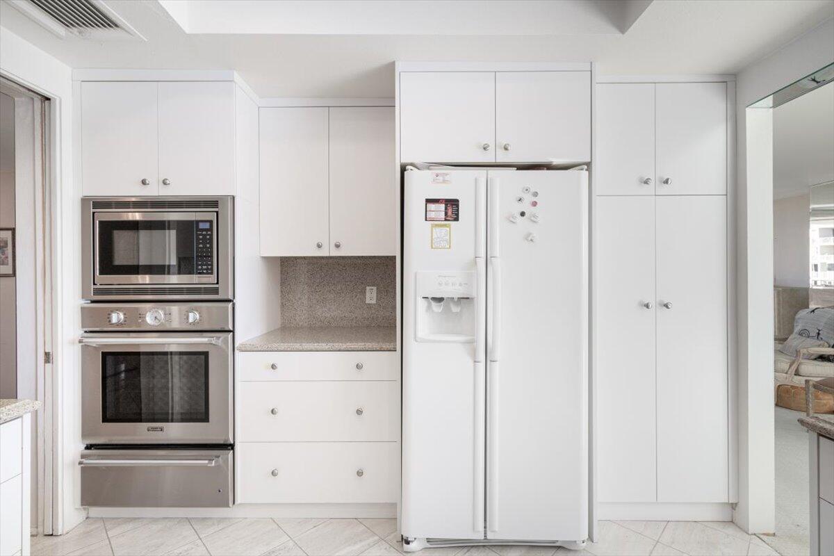 900 Island Drive, Unit 313 Rancho Mirage, CA 92270 - Photo 9 of 62 a kitchen with stainless steel appliances white cabinets and a sink