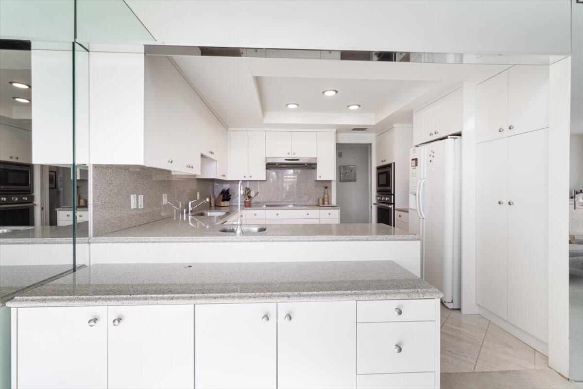 900 Island Drive, Unit 313 Rancho Mirage, CA 92270 - Photo 10 of 62 a kitchen with stainless steel appliances granite countertop a sink refrigerator and cabinets