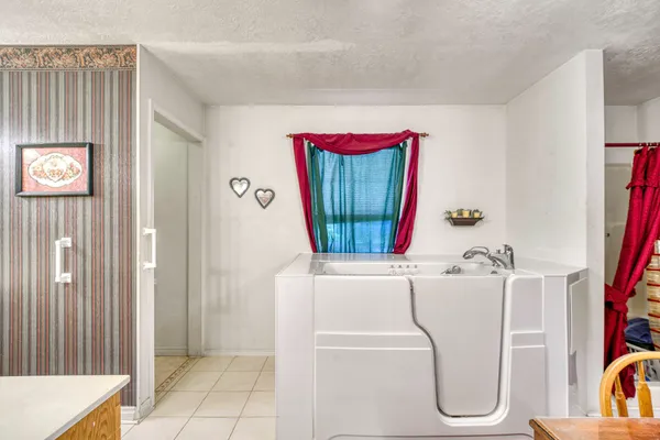 a bathroom with a tub sink and a mirror