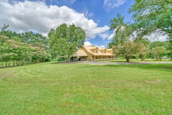 a front view of a house with a big yard and a fountain