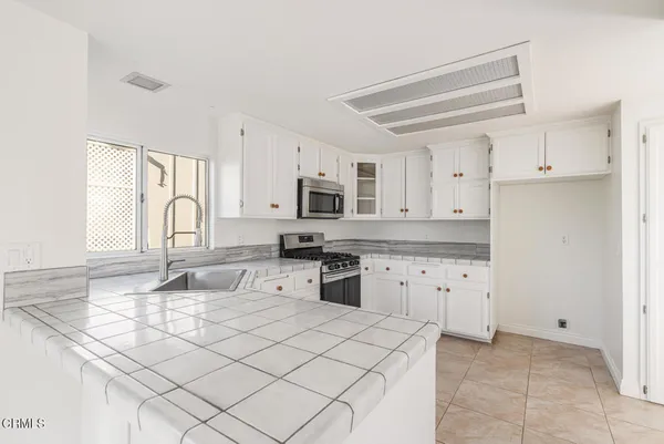 a kitchen with granite countertop cabinets stainless steel appliances and a window