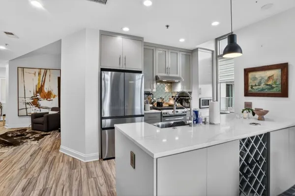 a kitchen with kitchen island a counter top space a sink stainless steel appliances and cabinets