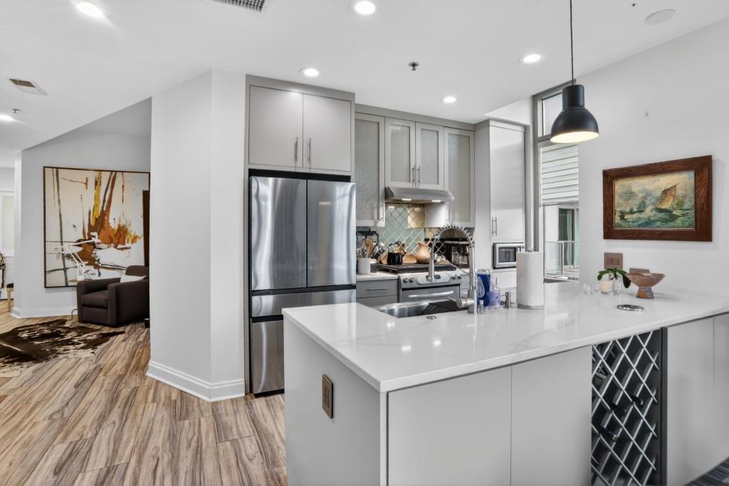 905 Juniper Street Northeast, Unit 403 Atlanta, GA 30309 - Photo 2 of 21 a kitchen with kitchen island a counter top space a sink stainless steel appliances and cabinets