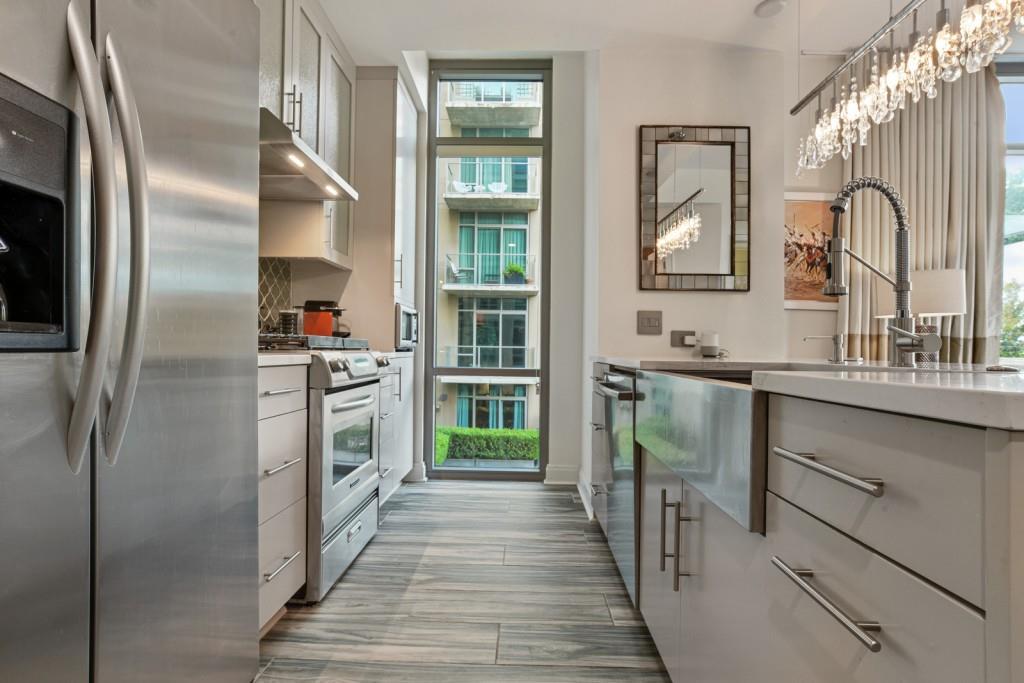 905 Juniper Street Northeast, Unit 403 Atlanta, GA 30309 - Photo 3 of 21 a kitchen with granite countertop a refrigerator and a sink