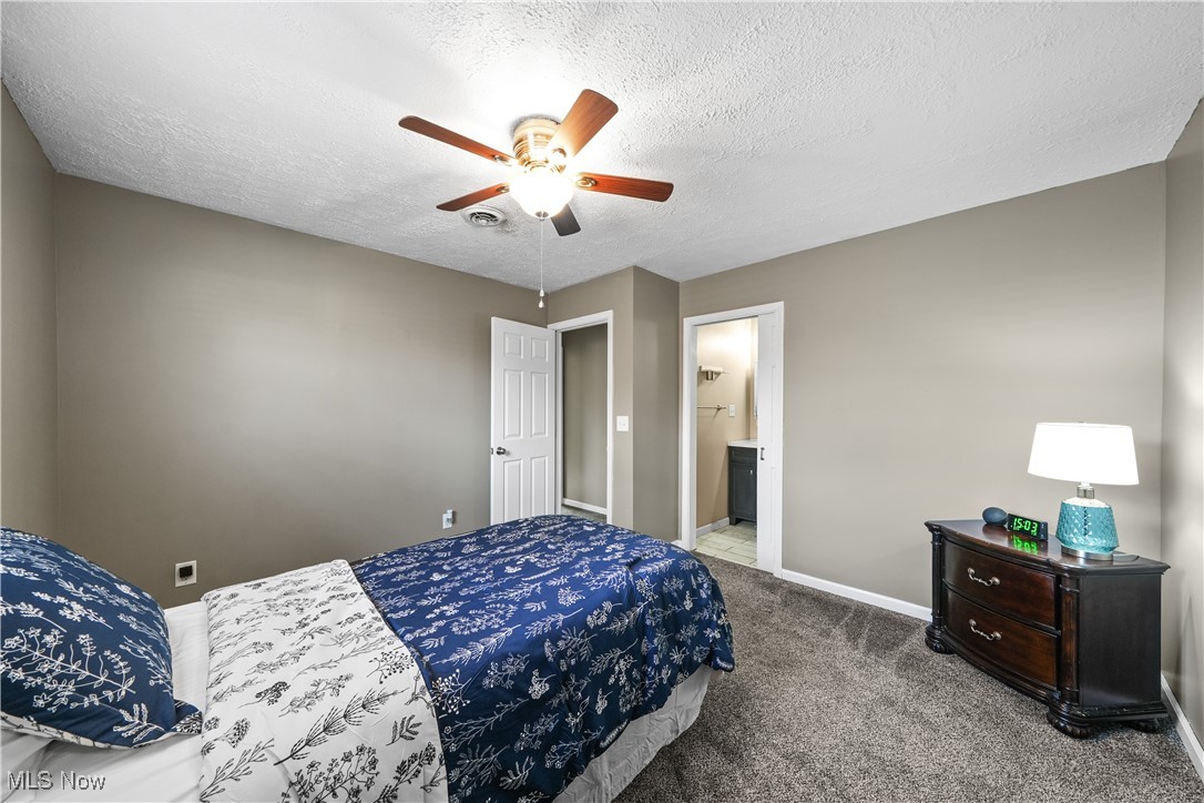 1503 Old Forge Road Kent, OH 44240 - Photo 17 of 38 Carpeted bedroom featuring ceiling fan, connected bathroom, and a textured ceiling