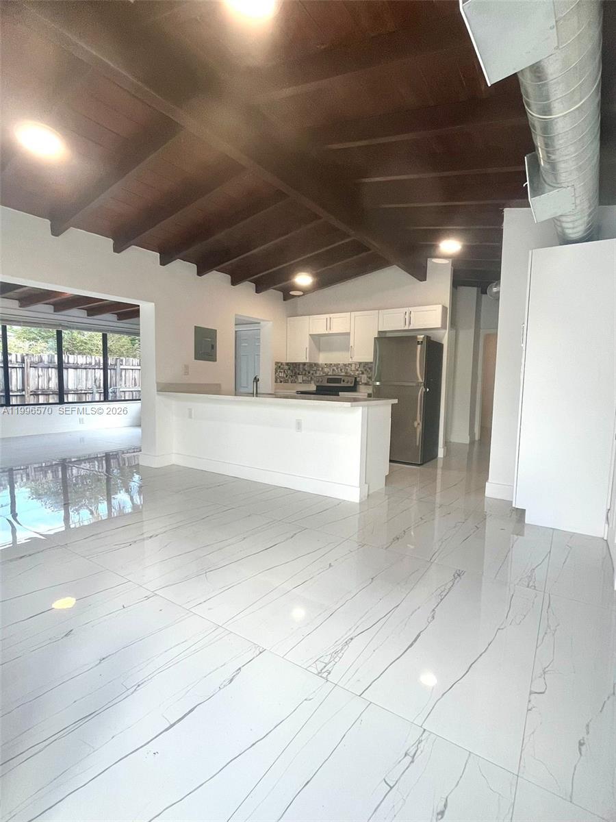 1776 Northeast 178th Street Miami, FL 33162 - Photo 2 of 18 a view of a hallway with wooden floor and chandelier