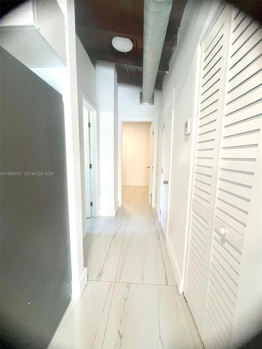 1776 Northeast 178th Street Miami, FL 33162 - Photo 8 of 18 a view of a hallway with a white walls
