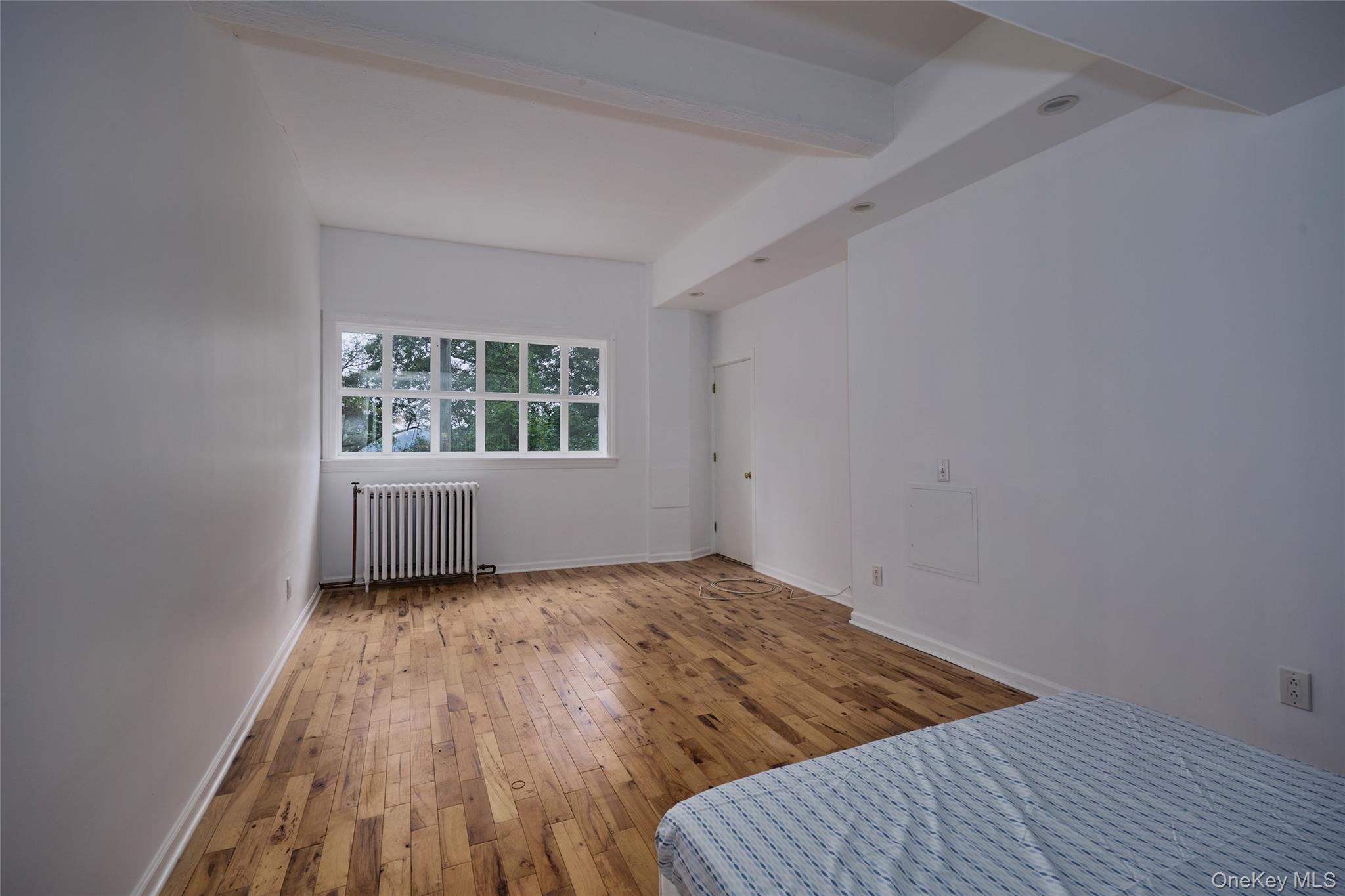 93 Circuit Road Tuxedo Park, NY 10987 - Photo 14 of 34 Unfurnished bedroom with beamed ceiling, hardwood / wood-style floors, and radiator heating unit