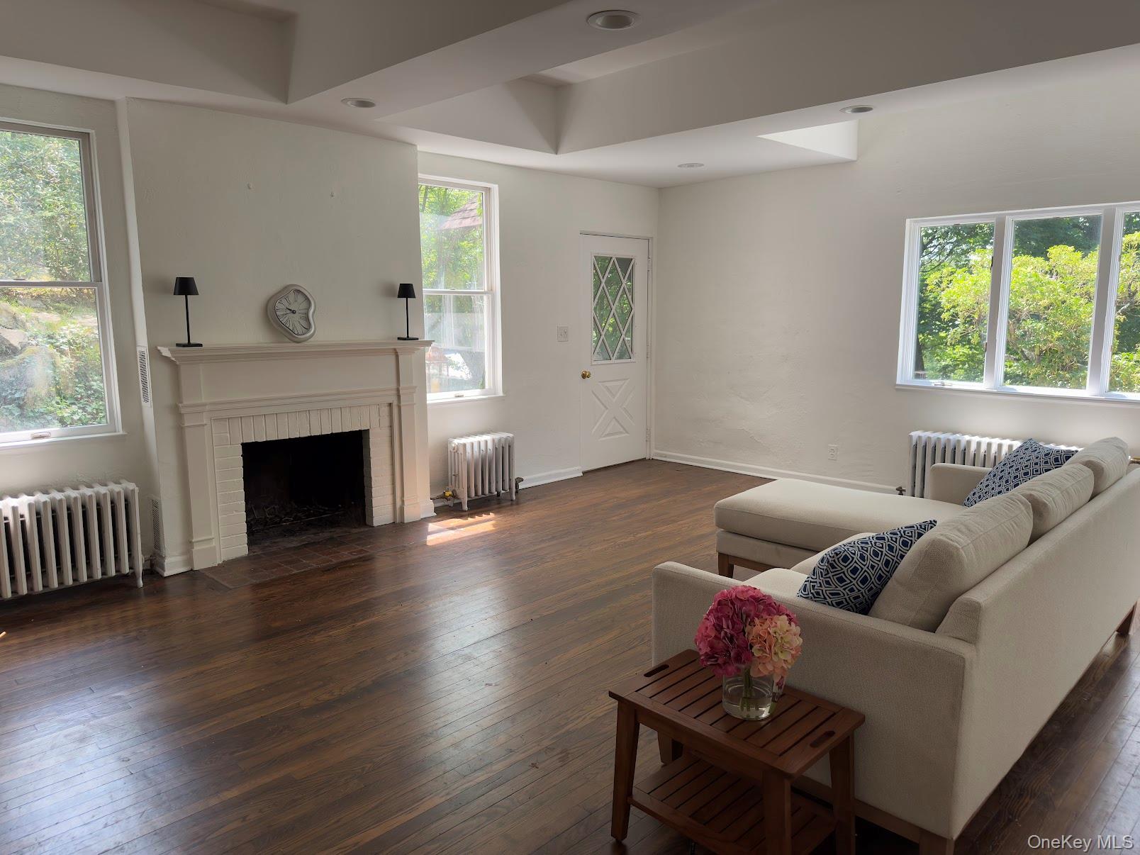 93 Circuit Road Tuxedo Park, NY 10987 - Photo 16 of 34 Living area featuring dark wood finished floors, radiator, and a fireplace