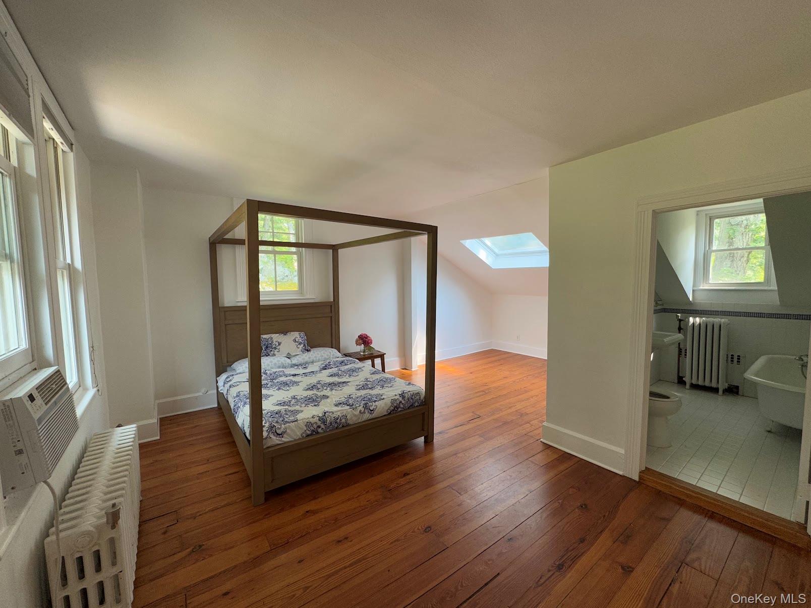 93 Circuit Road Tuxedo Park, NY 10987 - Photo 17 of 34 Bedroom with radiator heating unit, hardwood / wood-style floors, a skylight, lofted ceiling, and ensuite bathroom