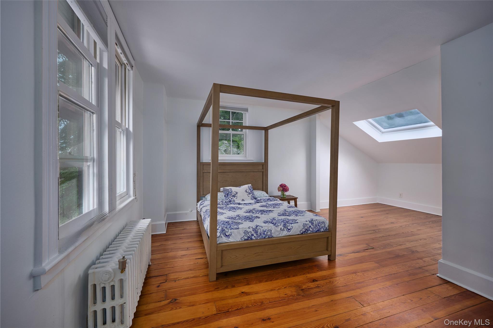 93 Circuit Road Tuxedo Park, NY 10987 - Photo 18 of 34 Bedroom with radiator heating unit, hardwood / wood-style floors, vaulted ceiling, and a skylight