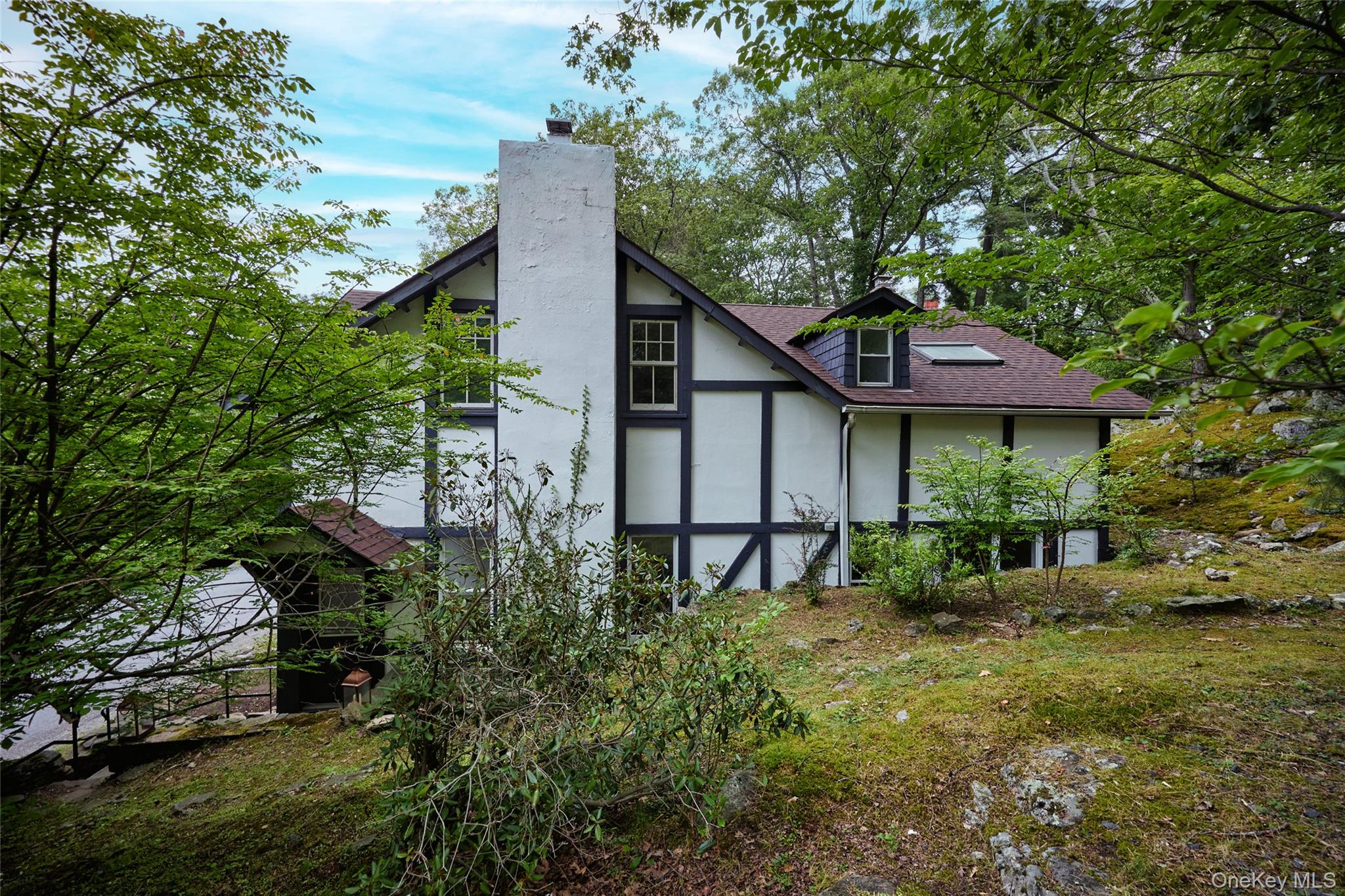 93 Circuit Road Tuxedo Park, NY 10987 - Photo 2 of 34 Back of property with a chimney, roof with shingles, and stucco siding