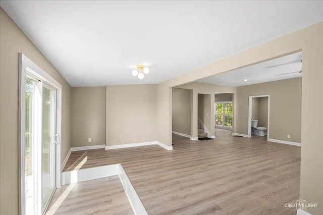 a view of an empty room with window and wooden floor