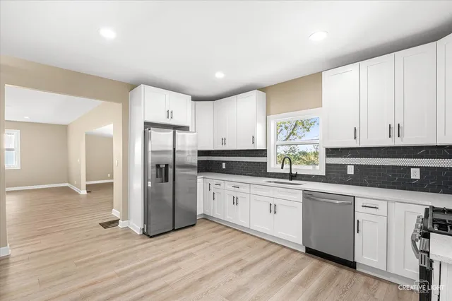 a kitchen with stainless steel appliances granite countertop a refrigerator and a stove top oven
