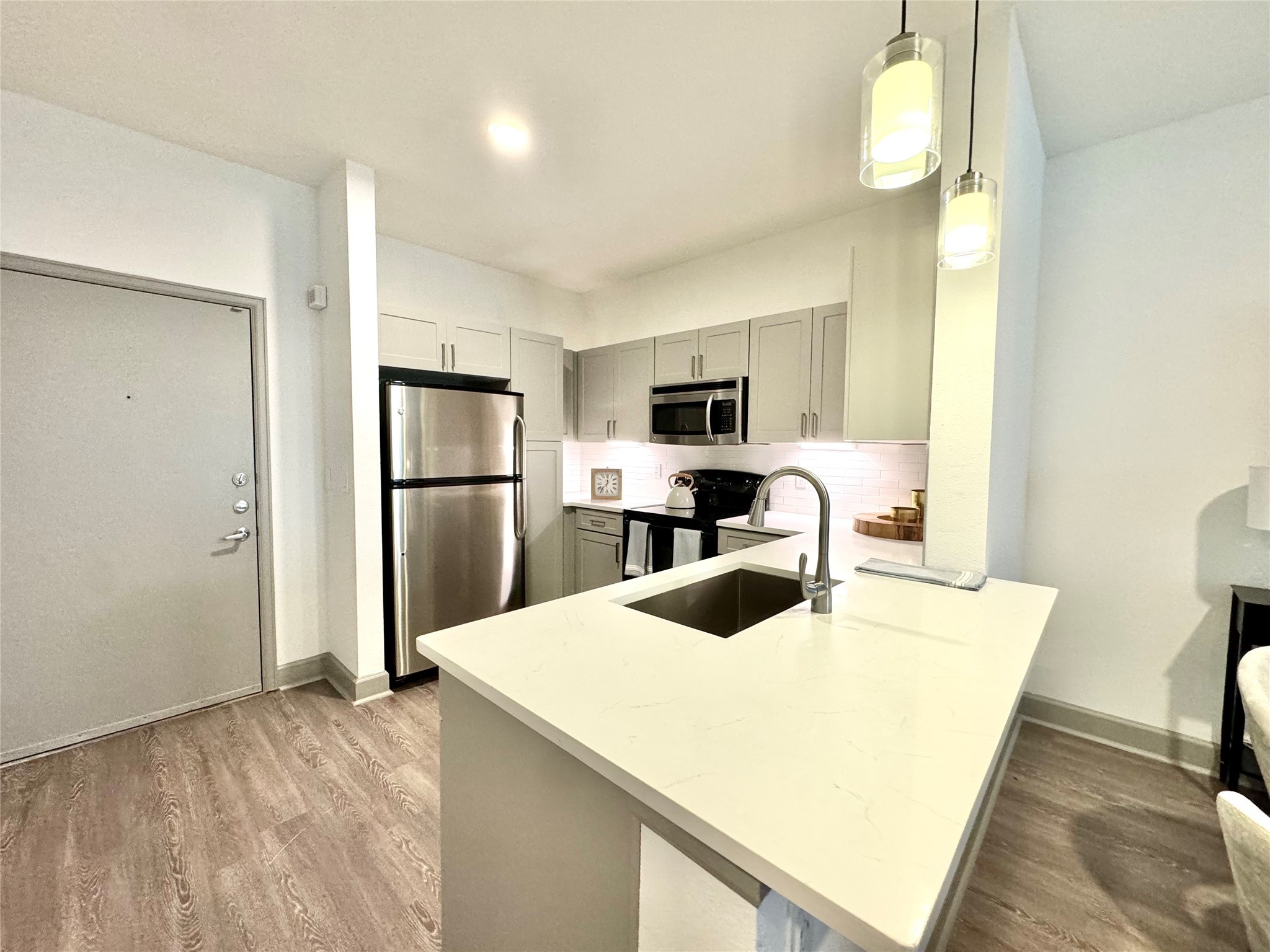 3333 Weslayan Street, Unit 1412 Houston, TX 77027 - Photo 5 of 20 a kitchen with kitchen island a sink appliances and a counter top space
