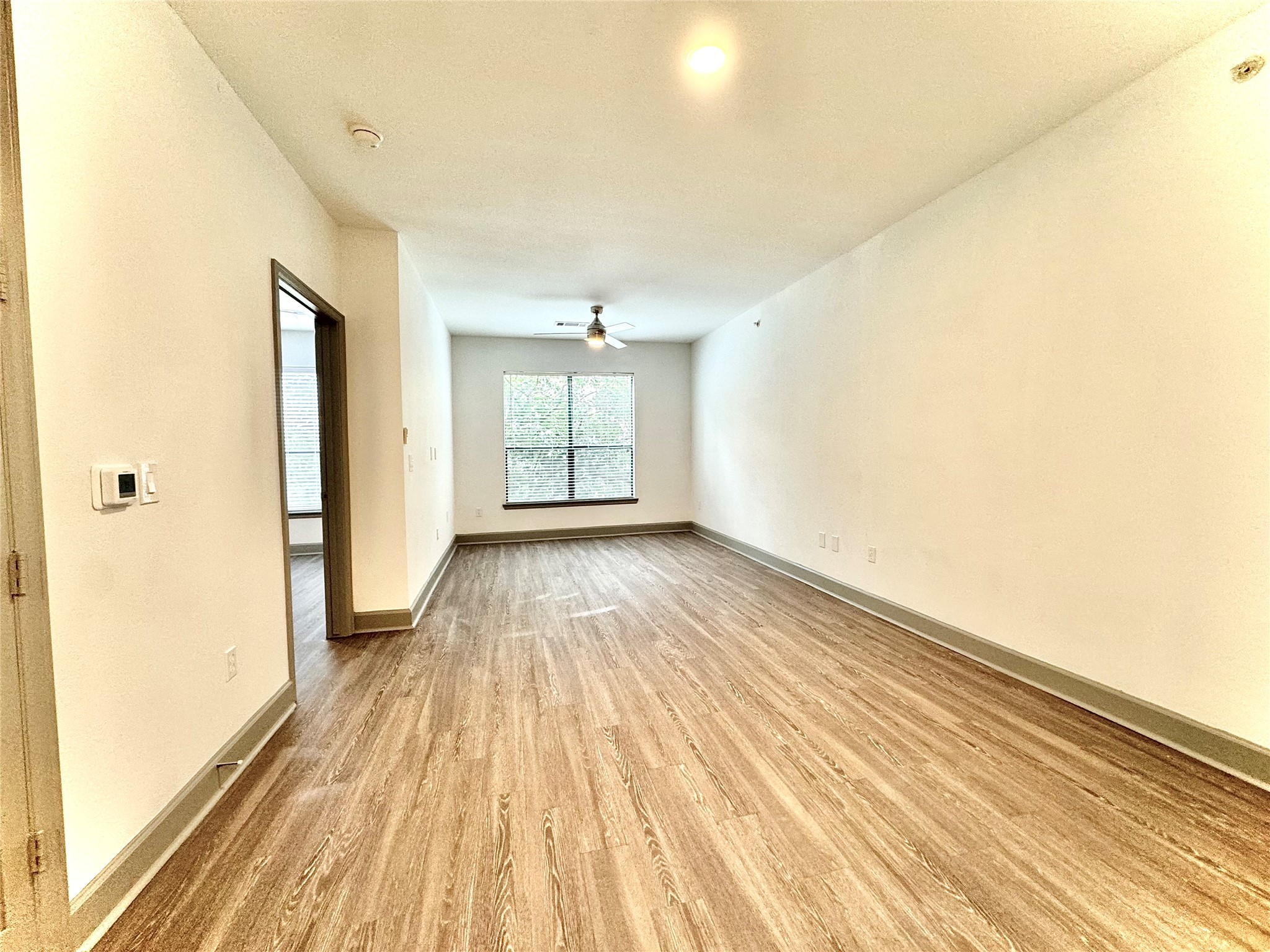 3333 Weslayan Street, Unit 1412 Houston, TX 77027 - Photo 7 of 20 an empty room with wooden floor and windows