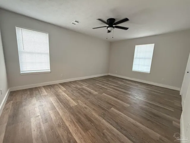 a view of an empty room with wooden floor