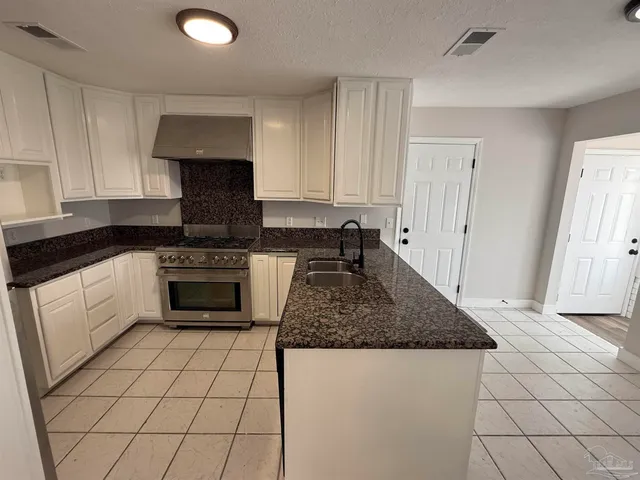 a view of empty room with wooden floor and cabinets