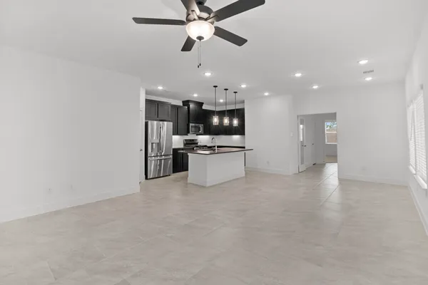 an empty room with a window and a fan