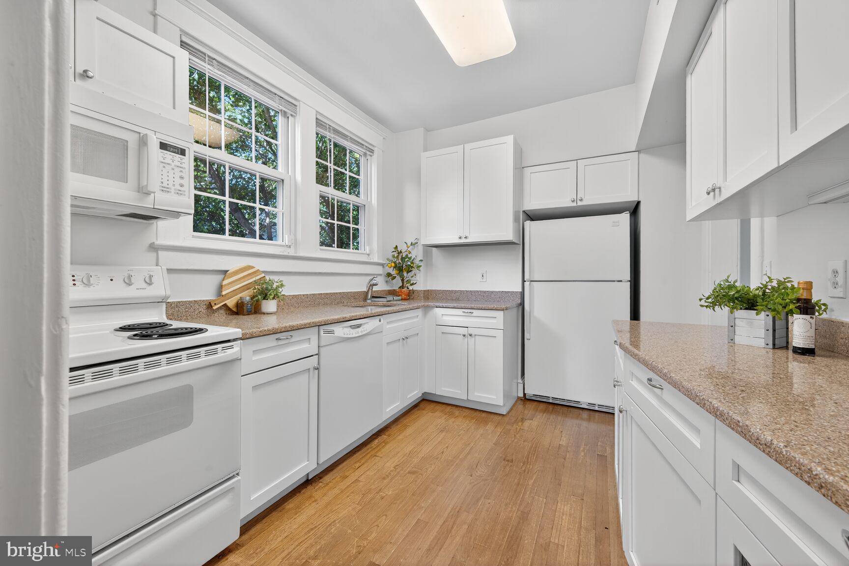 4209 Ellicott Street Northwest Washington, DC 20016 - Photo 13 of 33 a kitchen with white cabinets and white appliances