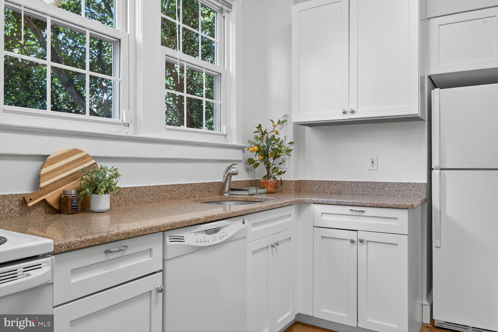 4209 Ellicott Street Northwest Washington, DC 20016 - Photo 14 of 33 a kitchen with white cabinets and window