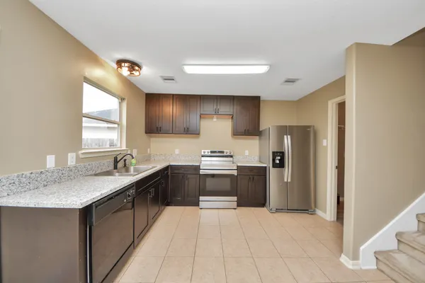 a kitchen with stainless steel appliances granite countertop a sink stove and refrigerator