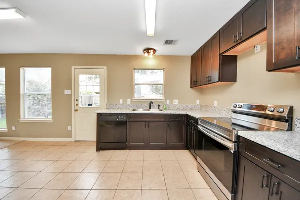 a kitchen with a sink a stove and cabinets