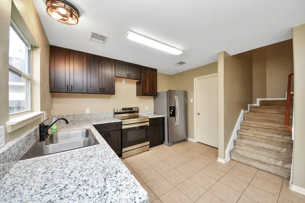 a kitchen with stainless steel appliances granite countertop a refrigerator and a sink