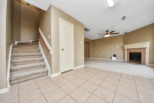 a view of an empty room with wooden floor and a fireplace