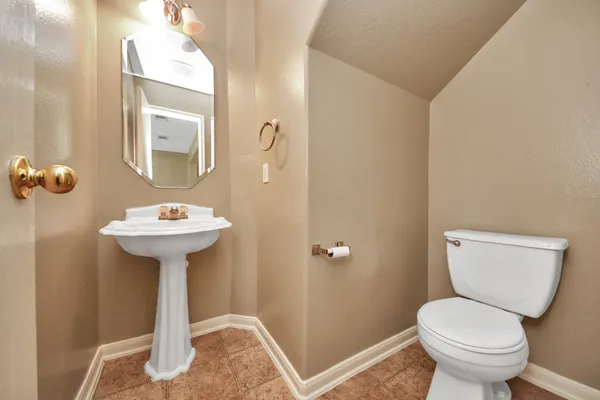 a bathroom with a sink toilet and a mirror