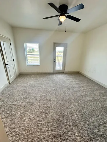 an empty room with windows and fan view