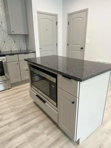a stove top oven sitting inside of a kitchen