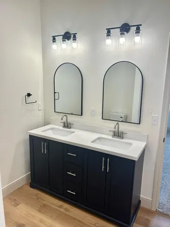 a bathroom with double vanity sinks and a mirror