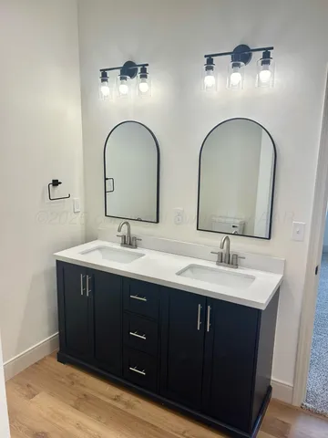 a bathroom with double vanity sinks and a mirror